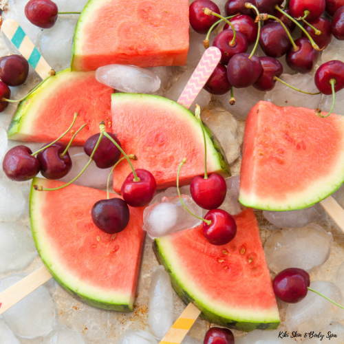 Colorful watermelon slices with fresh red cherries and ice pops arranged for food service presentation and wholesale distribution display.