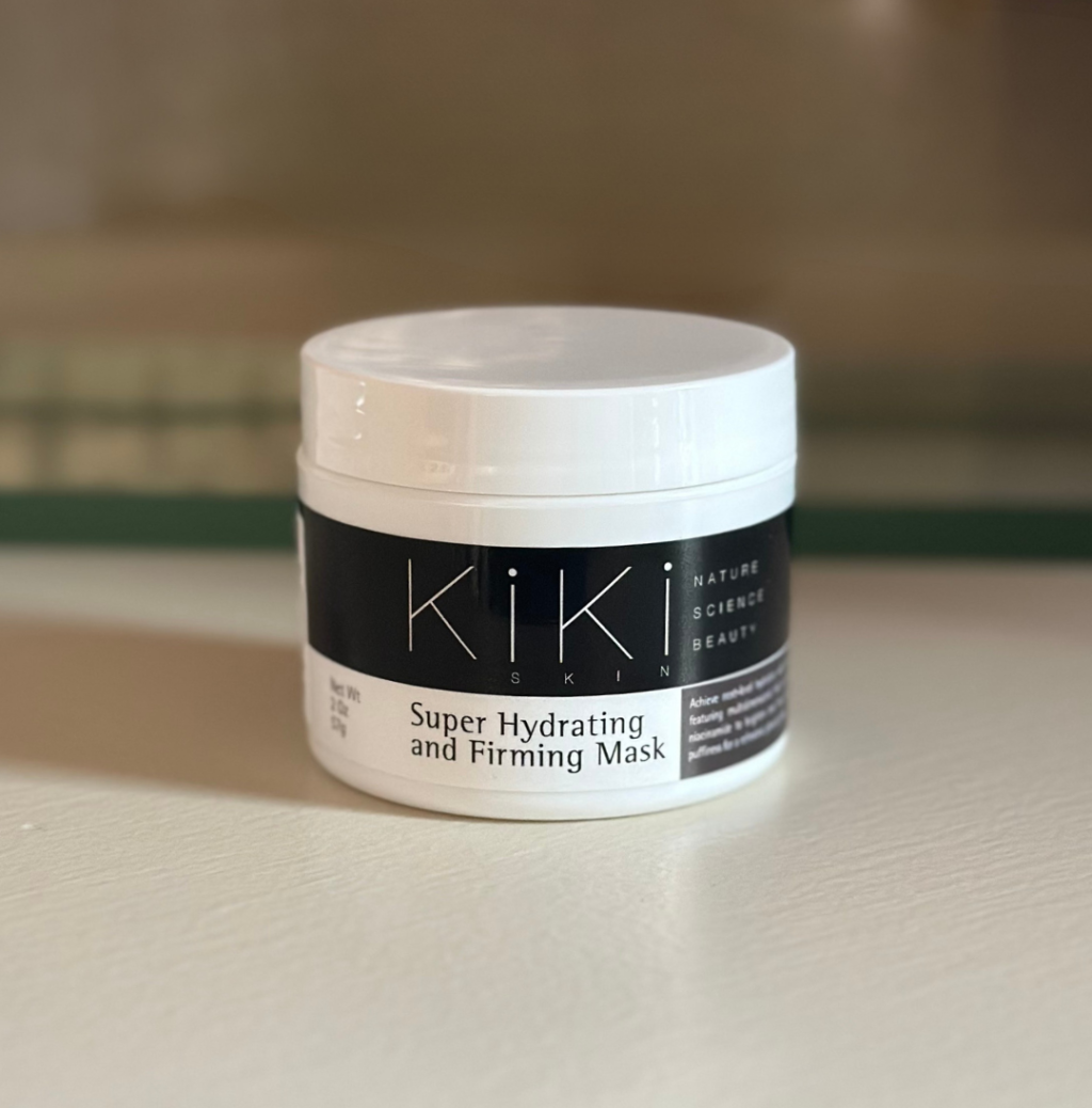 Kiki Ski Super Hydrating and Firming Mask in white container with black label on wooden surface.