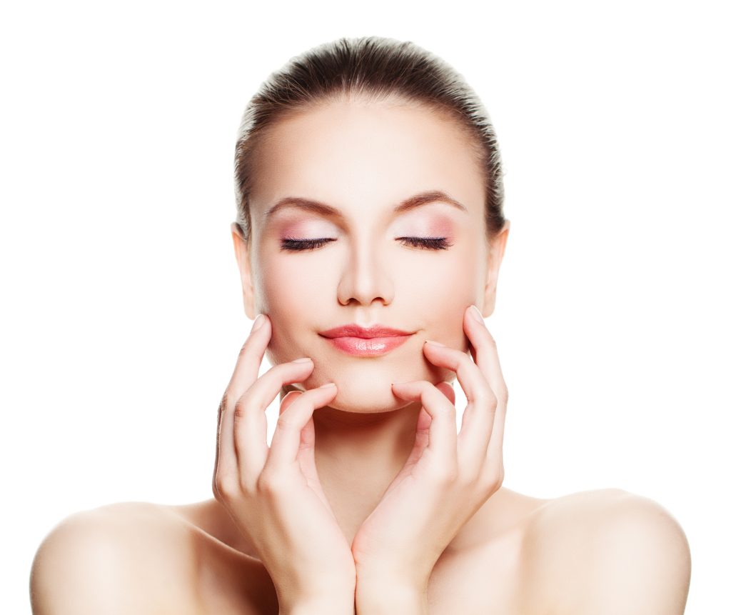 Woman with eyes closed and hands gently touching her face, showing healthy glowing skin